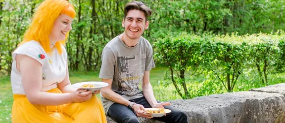 Zwei Auszubildende essen im Garten des Bundesbildungswerks Rummelsberg