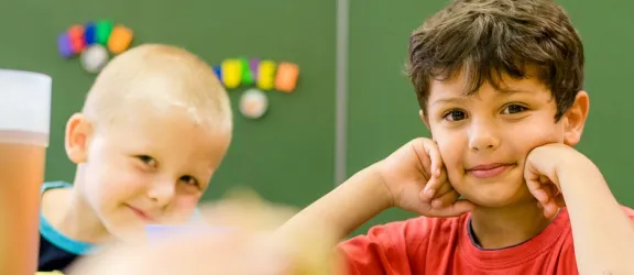 Zwei Kinder sitzen an einem Tisch in der SVE