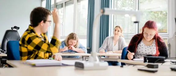 Drei Schüler und Lerhrerin im Klassenzimmer der Förderberufsschule