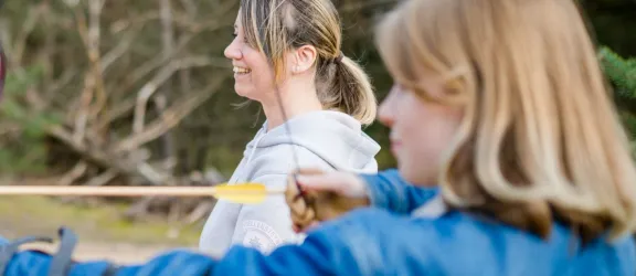 Jugendliche mit Pädagogin beim Bogenschießen im Rahmen der Jugendhilfe