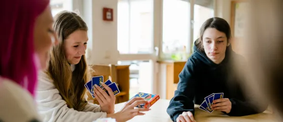 Jugendliche beim Kartenspielen während der Sozialen Gruppenarbeit