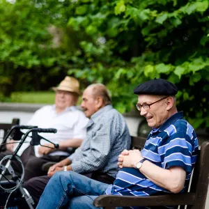 Vier alte Menschen sitzen draußen 