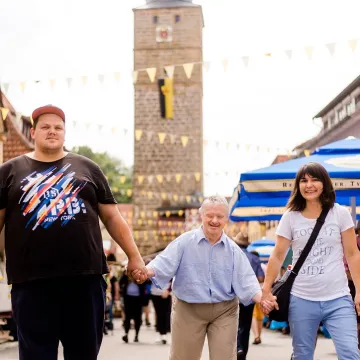 Drei Menschen laufen an der Hand durch Hassfurt