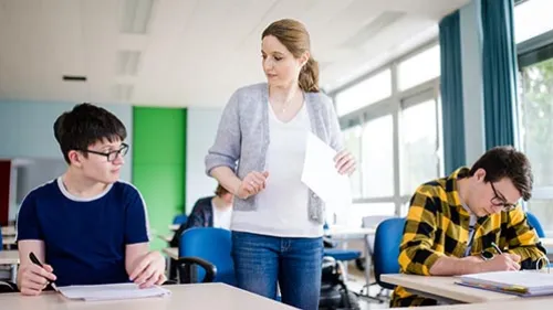 Azubis lernen in der Berufsschule mit Lehrerin