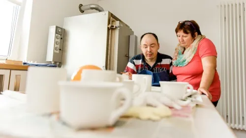 Zwei Menschen töpfern einen Teller