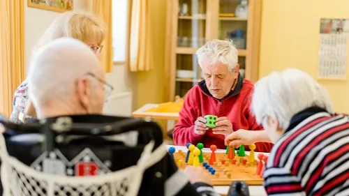 Vier alte Menschen spielen Mensch ärgere dich nicht