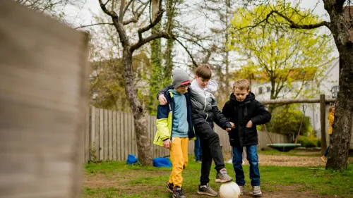 Drei Jungen beim Kicken im HPT-Garten